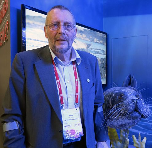 El investigador escocés Bernie McConnell, junto a una reproducción de foca común.