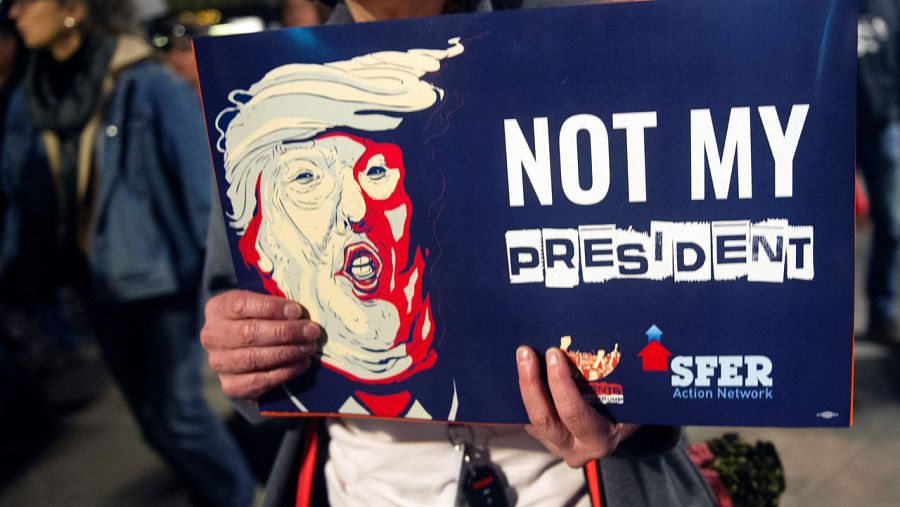 Un manifestante anti Trump sujeta una pancarta con el lema: 
