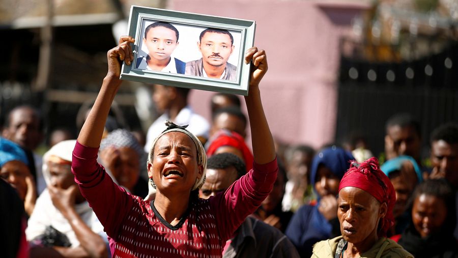 Una mujer nuestra una fotografía de sus familiares desaparecidos en el deslizamiento de tierra de un vertedero en Etiopía.