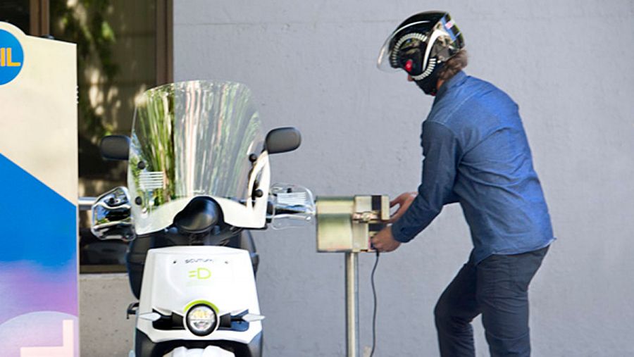 Un conductor recarga su motocicleta en un punto de recarga.