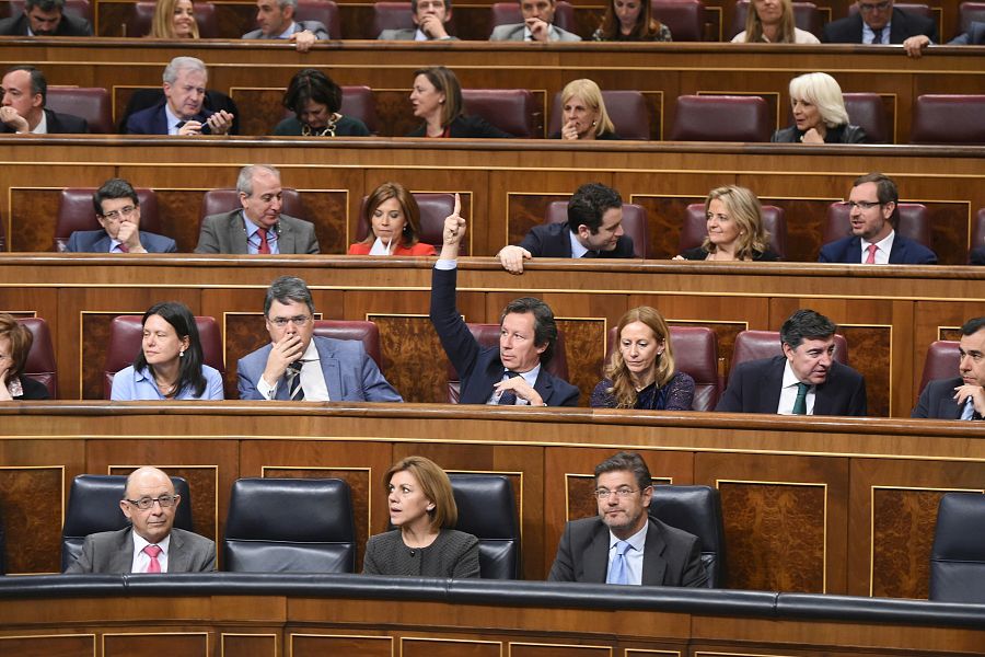 El portavoz adjunto del PP Carlos Floriano marca el sentido del voto para los diputados de su grupo