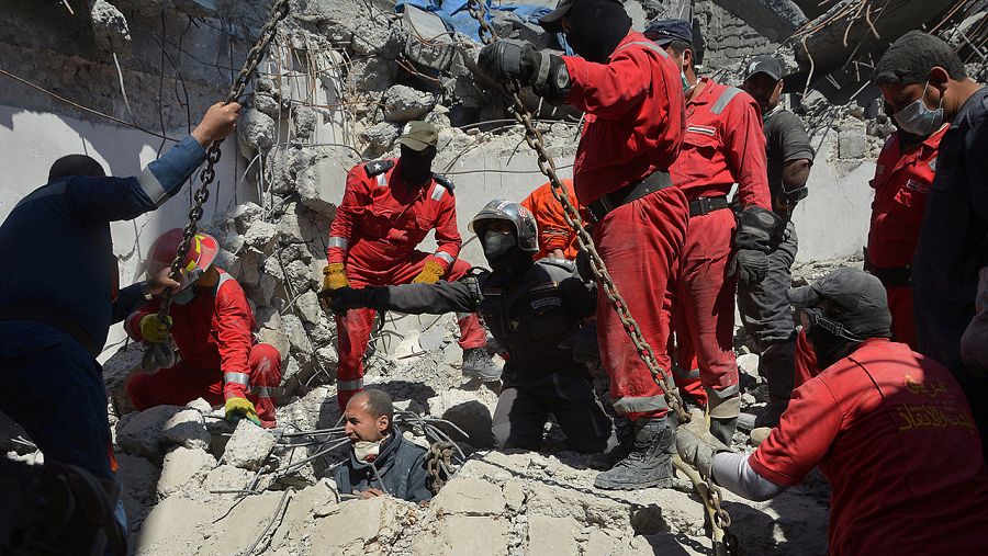 Bomberos buscan cuerpos entre los escombros del edificio derruido tras un ataque de la coalición internacional en Mosul