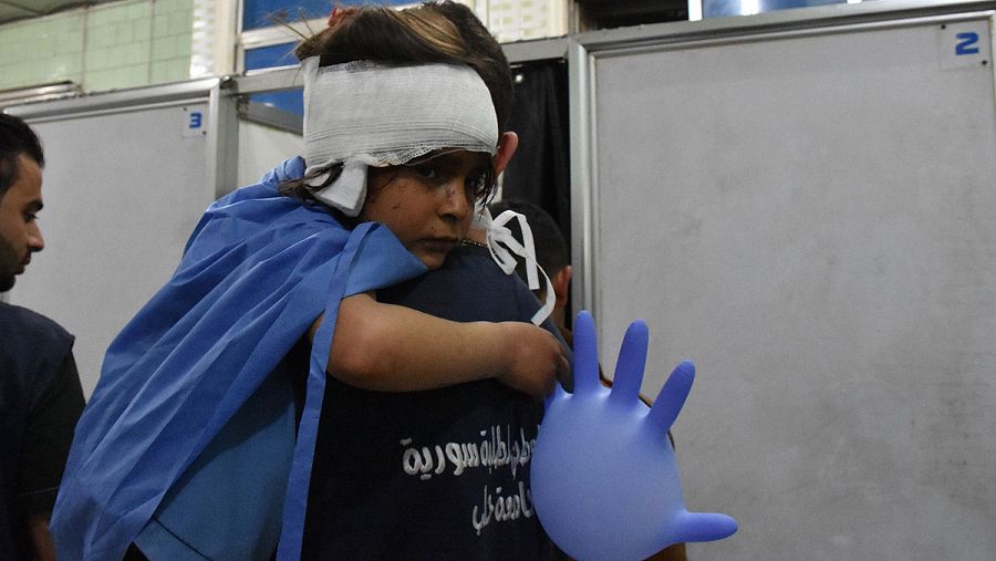 Una niña herida en el atentado contra los evacuados en Alepo sostiene un guante inflado a modo de globo
