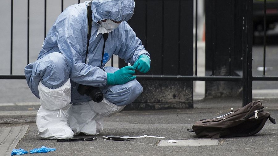 Un policía forense busca pruebas en Whitehall, en el centro de Londres, junto a los cuchillos y la mochila del sospechoso que ha sido arrestado