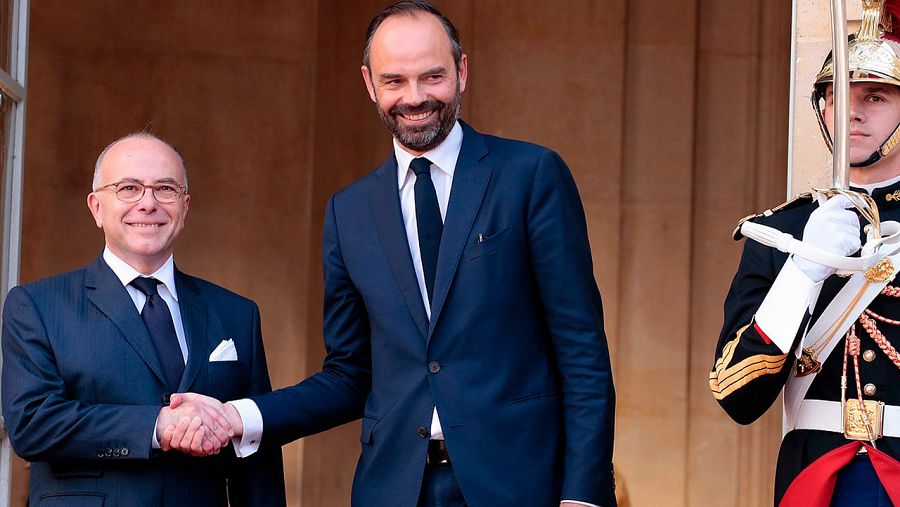El nuevo primer ministro francés, Edouard Philippe (derecha), da la mano a su predecesor, Bernard Cazeneuve, durante el traspaso de poderes en el Palacio de Matignon