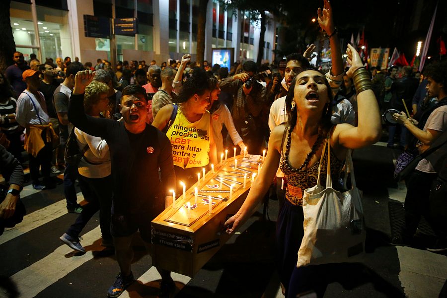 Manifestantes cargan con una representación del ataúd del presidente.