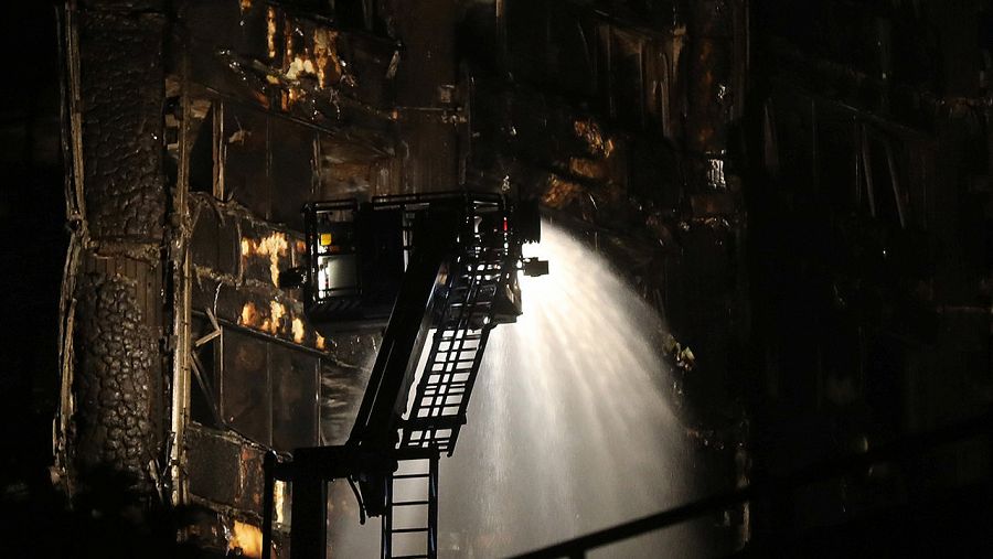 Los bomberos usan la manguera para apagar las llamas en la Torre Grenfell de Londres durante la madrugada del jueves