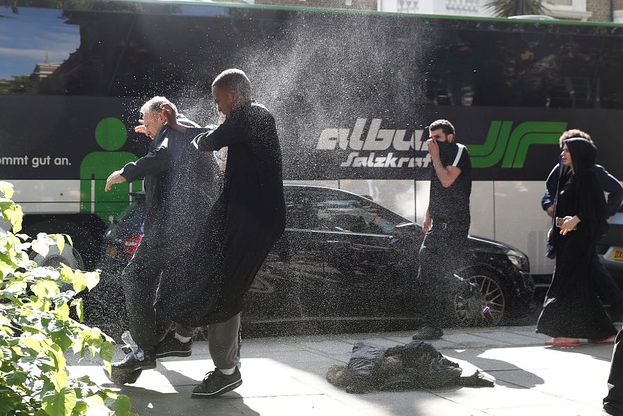 Un manifestante ataca a un hombre al que cree Robert Black, el director de la propietaria del edificio.
