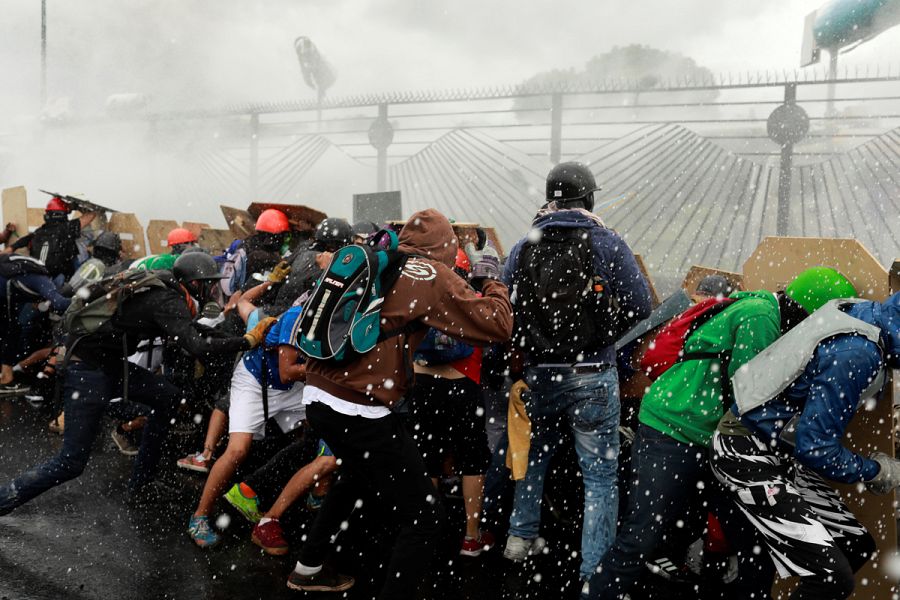 Los manifestantes echan abajo las vallas de la base militar de La Carlota, en Caracas.