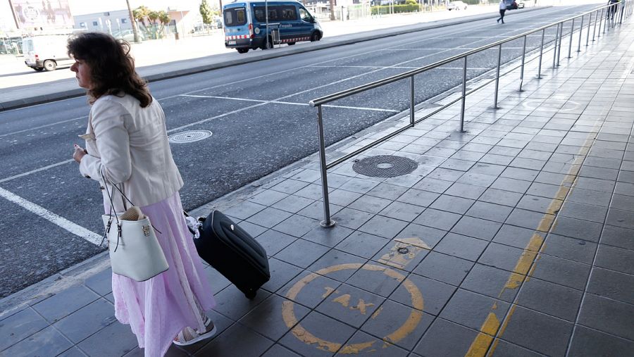 Una usuaria del aeropuerto del Prat (Barcelona) espera en vano la llegada de un taxi.