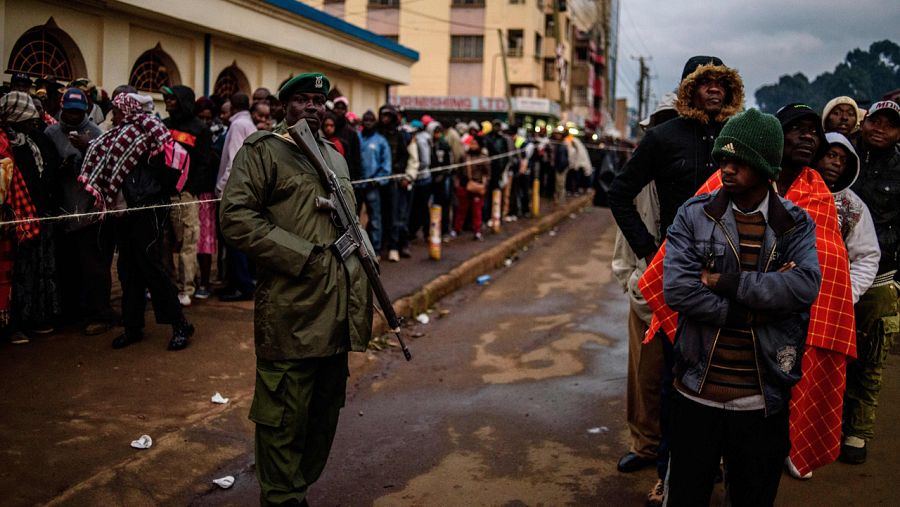 Efectivos de seguridad kenianos vigilan las colas de votantes en un colegio electoral de Eldoret, Kenia