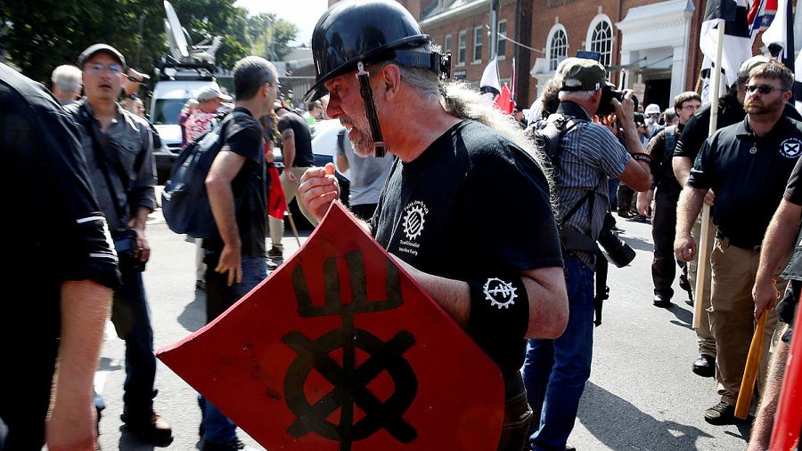 Un hombre con el escudo y la camiseta del Partido Obrero Tradicionalista, un grupo de extrema derecha
