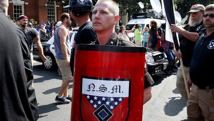 Un participante en la marcha racista de Charlottesville con un escudo del grupo neonazi National Socialist Movement (Movimiento Nacional Socialista)