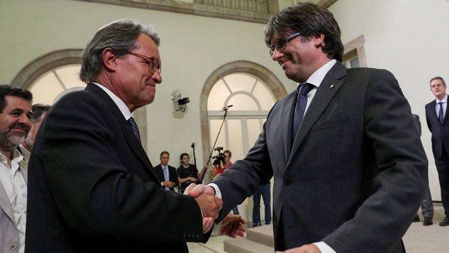 Puigdemont saluda a Mas al termino de su declaración institucional.