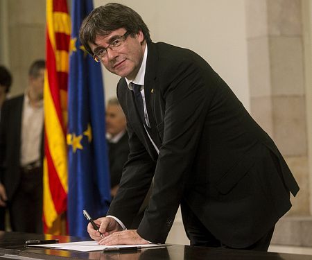 Carles Puigdemont firma un documento después de comparecer ante el pleno del Parlament