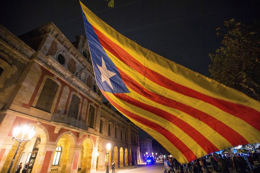 Una 'estelada' ondea frente al Parlament de Cataluña, donde se han congregado miles de personas