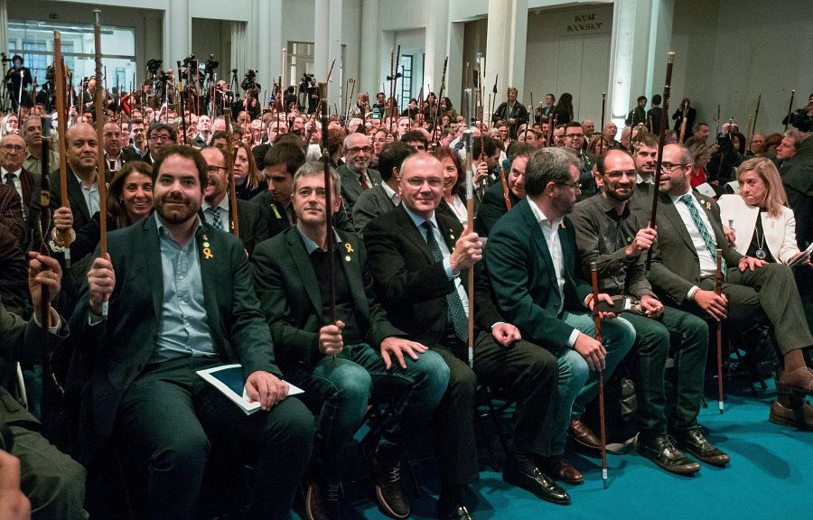 Los alcaldes independentistas congregados en Bruselas levantan su vara de mando, símbolo de su poder municipal.