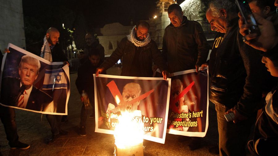 Un grupo de palestinos quema unos carteles con la imagen de Donald Trump