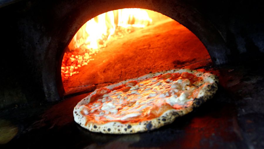 Pizza Margherita is prepared in a wood-fired oven at L'Antica Pizzeria da Michele in Naples