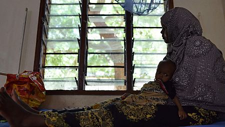 Una madre acurruca a su hijo malnutrido en el campo de refugiados de Dadaab