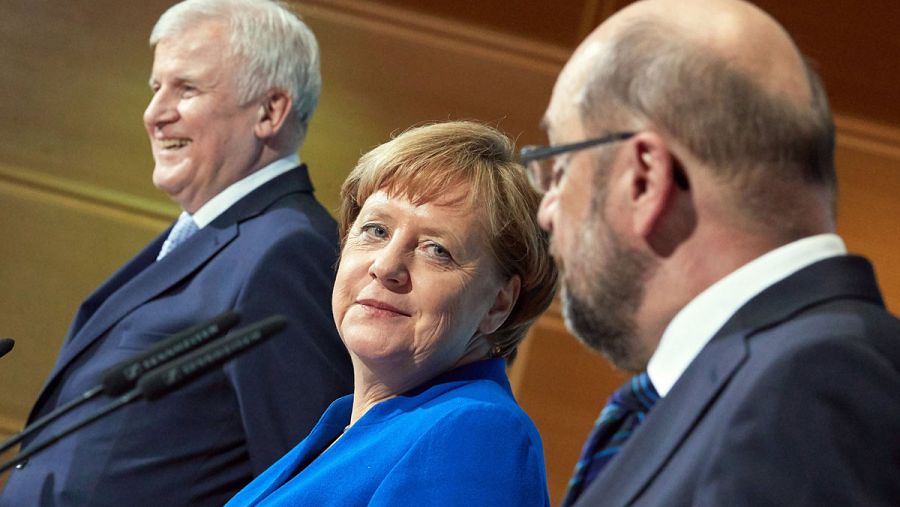 Merkel sonríe al líder socialdemócrata, Martin Schulz, al anunciar el principio de acuerdo para una nueva gran coalición 