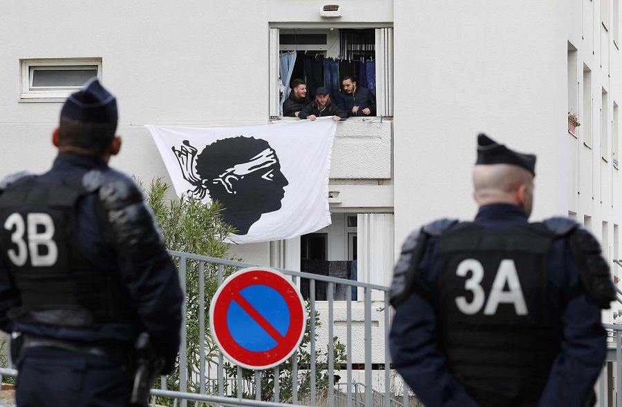 Varios jóvenes despliegan una bandera corsa frente al centro cultural Alb'Oru de Bastia, donde Macron ha ofrecido su discurso