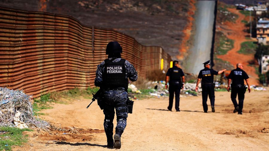Policías federales custodian la valla fronteriza que delimita a México con EE.UU.