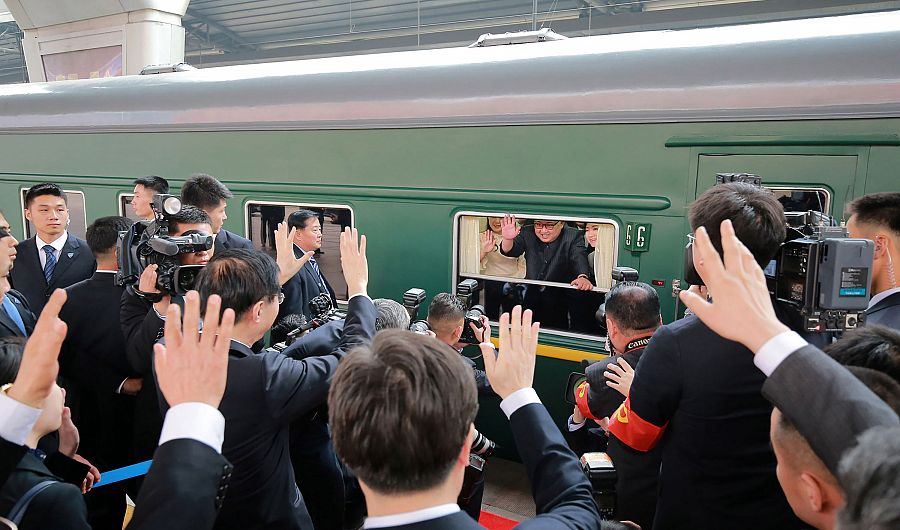 El líder norcoreano, Kim Jong-un, y su esposa, Riu Sol Ju, saludan desde el tren en el que han viajado a China
