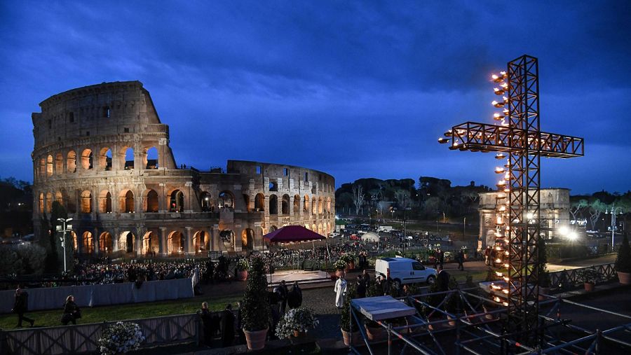 Una cruz adornada con velas es vista junto al Coliseo, en Roma