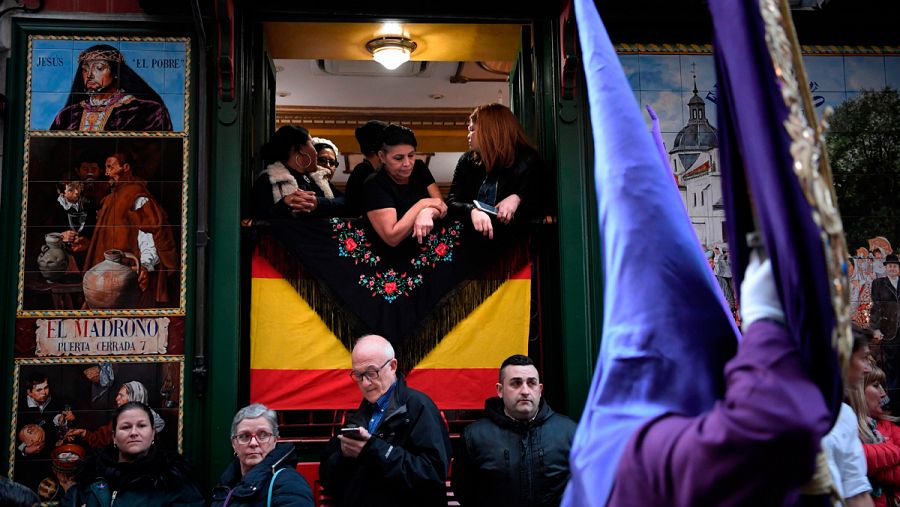 Clientes de un bar observan una procesión en Madrid