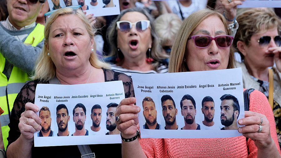 Dos mujeres enseñan las fotografías de los miembros de 'La Manada' en la protesta de Valencia