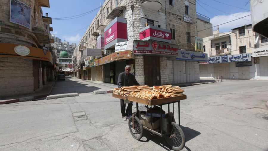 Un vendedor palestino trata de vender pan en una calle desierta de la ciudad cisjordana de Nablús