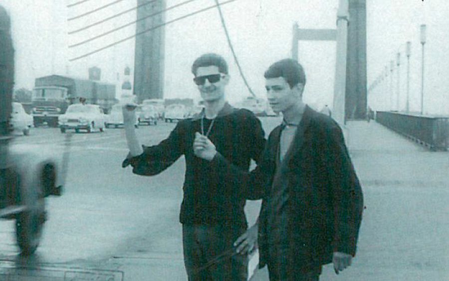 Un joven Kim y un amigo haciendo autostop