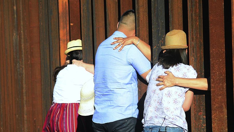 Abrazando a sus madres en las verja entre Méjico y EE.UU.