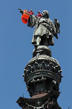 Activists from the Spanish Proactiva Open Arms charity place a life jacket on the Christopher Columbus statue in Barcelona