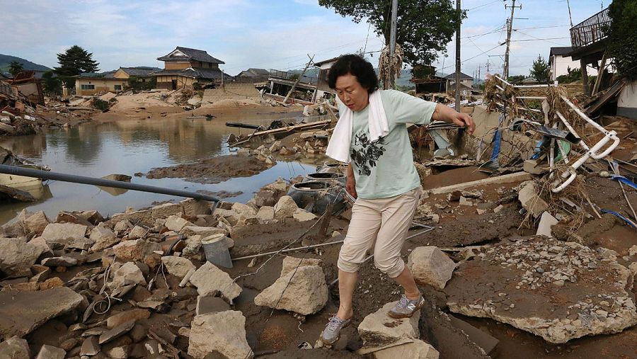 Una mujer camina por los escombros ocasionados por las inundaciones en la ciudad japonesa de Kurashiki.