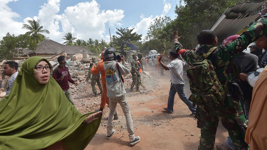 Varias personas se ven sorprendidas por el nuevo terremoto en Lombok (Indonesia) mientras participaban en las labores de desescombro del seismo anterior. Fuente: ADEK BERRY / AFP