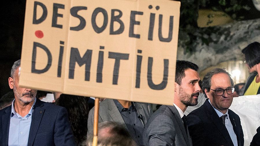 El presidente de la Generalitat, Quim Torra, y el presidente del Parlament, Roger Torrent, hablan con los manifestantes que portan carteles con lemas como 