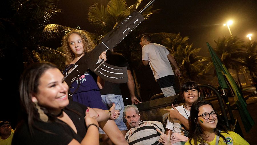 Partidarios de Jair Bolsonaro posan con un arma de cartón y un muñeco que representa al expresidente Lula preso