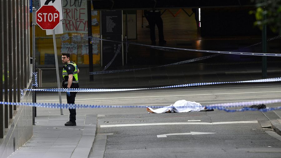 Un policía junto a un cuerpo en el suelo en Bourke Street, Melbourne (Australia). Un hombre ha apuñalado a varias personas en la calle. Foto: AAP/James Ross/via REUTERS