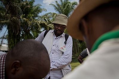 Tres miembros de MSF avanzan por las calles de Lulingu, con Severin Ndo situado a la derecha del grupo.