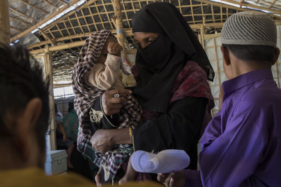 Momtaz, con uno de sus hijos en brazos, espera de ser atendida en una consulta médica