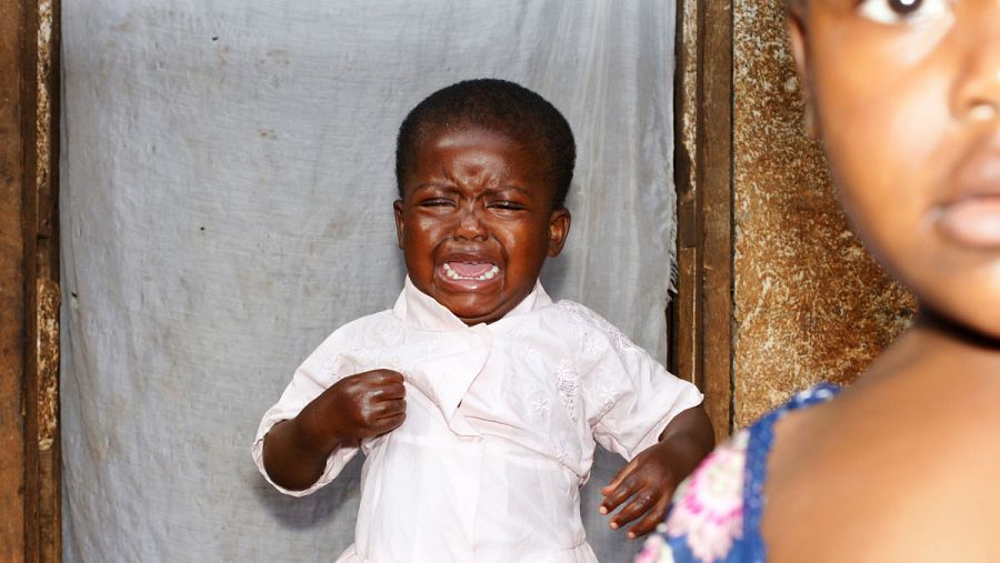 Un niño camerunés llora en la puerta de su casa