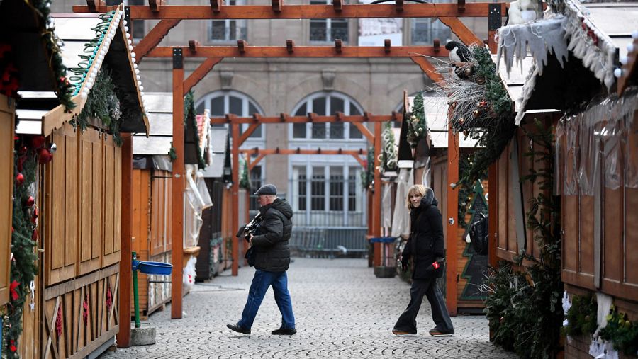 Dos reporteros caminan entre las casetas cerradas del mercadillo navideño objeto de un atentado perpetrado ayer, en Estrasburgo (Francia)