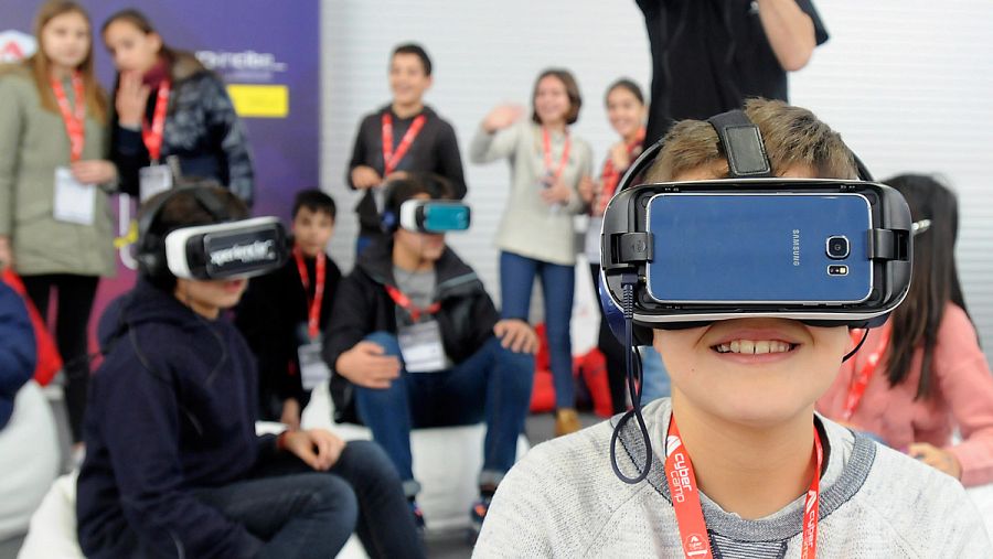 NIños utilizando el teléfono móvil en un campus tecnológico