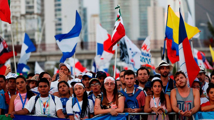 Peregrinos con sus banderas esperan tras una valla a que dé comienzo la celebración.