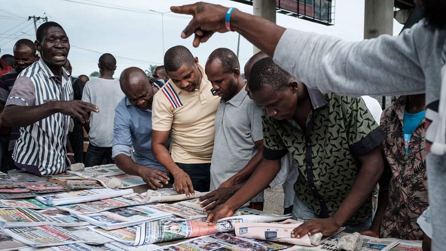 Un grupo de hombres comentan los periódicos del día en una calle de Nigeria.
