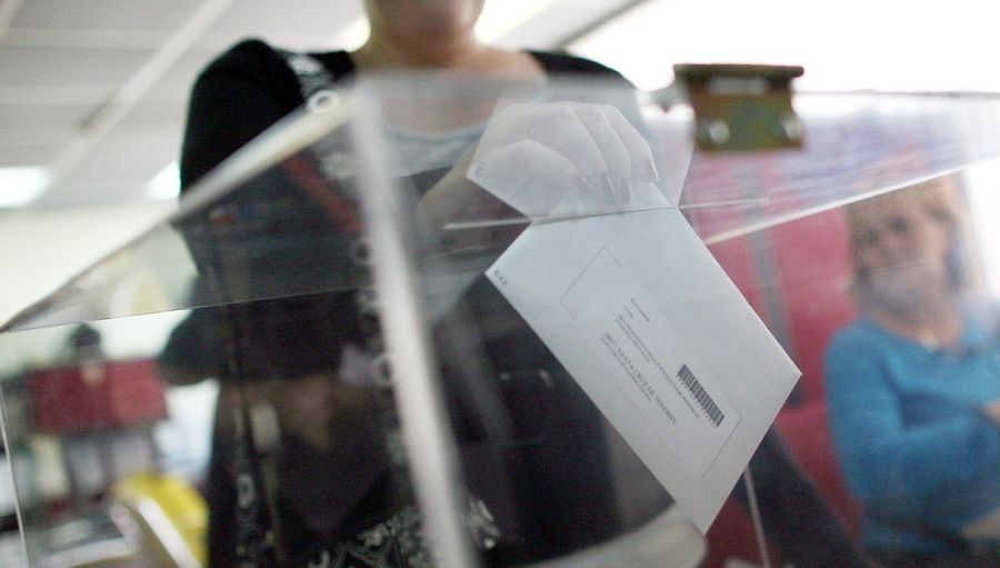 Una española vota en urna en el consulado de Caracas (Venezuela) en 2011. El sobre va dirigido a su mesa electoral española