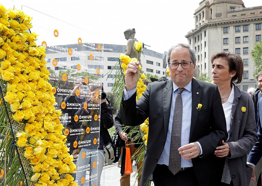 Torra coloca rosas amarillas en el mural que recuerda a los independentistas presos.