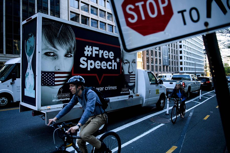 En esta foto de archivo tomada el 16 de abril de 2019, los ciclistas pasan un camión con un cartel de protesta que dice 